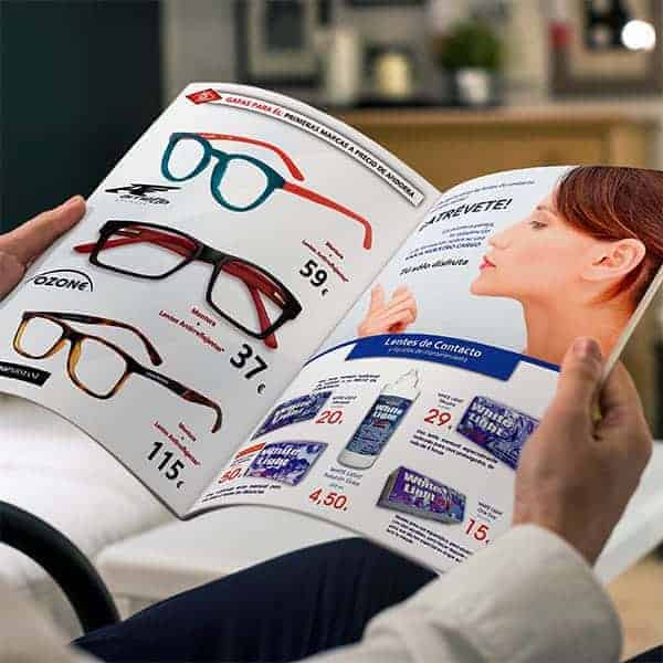 Brazos sujetando el catálogo de ofertas de Óptica Andorrana donde se ven varias gafas de sol y gafas graduadas a precios increíbles