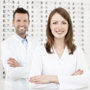 Dos profesionales de Óptica Andorrana posan frente al muestrario de gafas de las mejores marcas